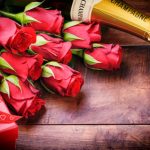 Rote Rosen mit Geschenk und Sekt